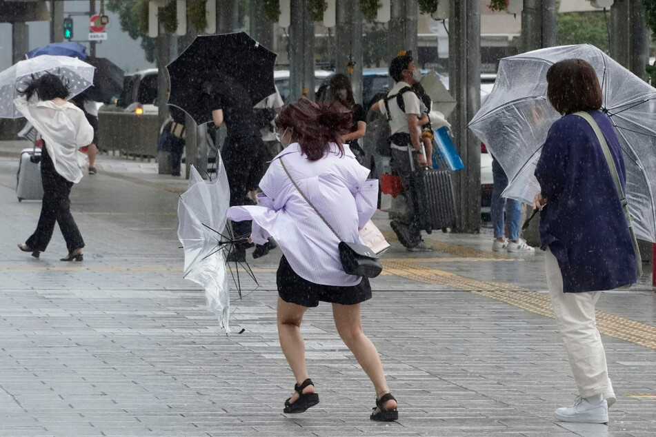 Auch in Hamamatsu kämpfen sich die Menschen mit starkem Wind und Regen ab.