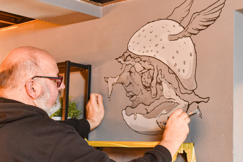 Andy K. verzierte am Samstag eine Wand des Lokals mit einem geflügelten Burger. Die freie Illustration des Künstlers macht Appetit und gute Laune.