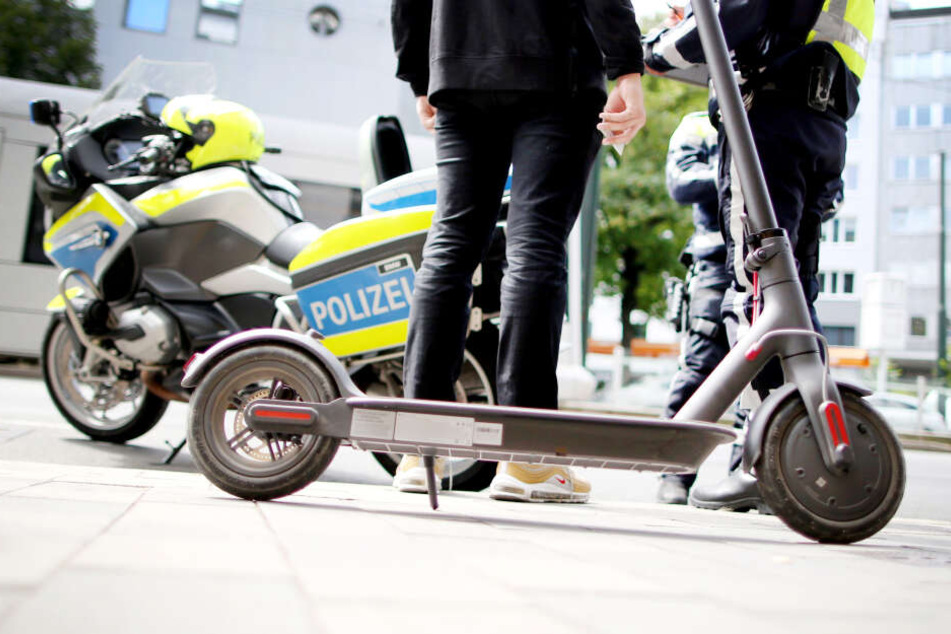 Polizisten kontrollieren in der Innenstadt von Düsseldorf einen E-Scooter-Fahrer.