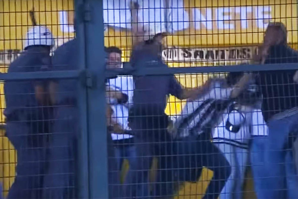 Polizisten dreschen auf Santos-Anhänger ein.