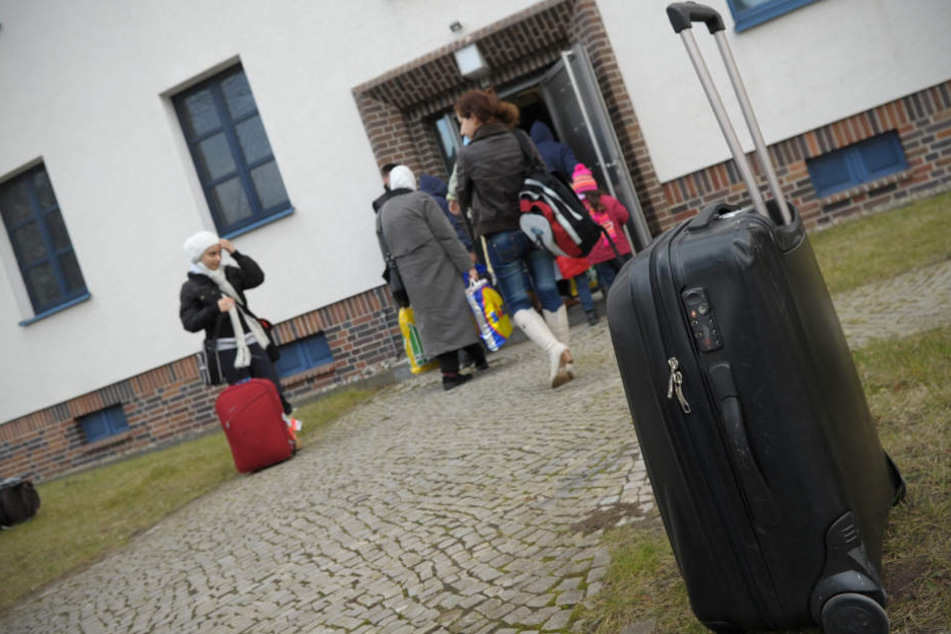 Flüchtlinge vor einer neuen Flüchtlingsunterkunft. In Ludwigsburg soll es bald Würfelgebäude, sogenannte Cubes, geben. (Symbolbild)