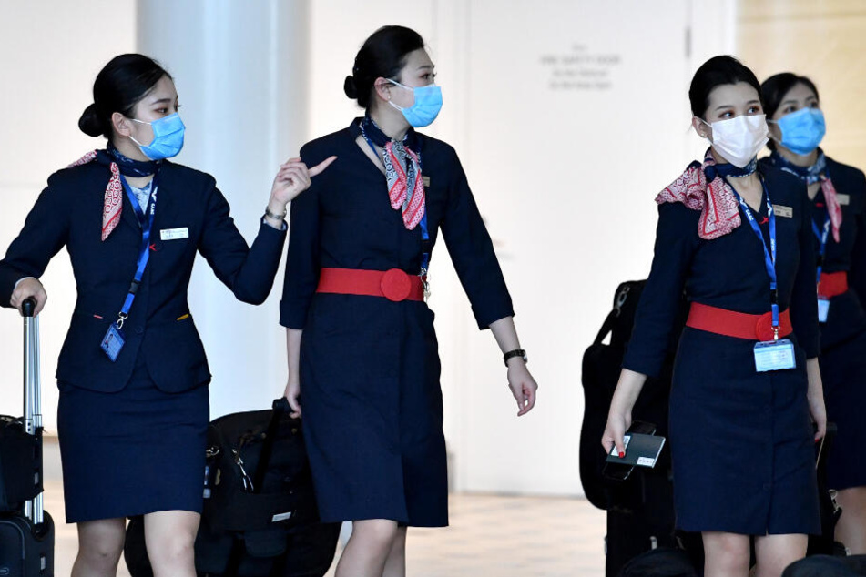 Mitarbeiterinnen der China Eastern Airlines tragen zur Uniform einen Mundschutz.