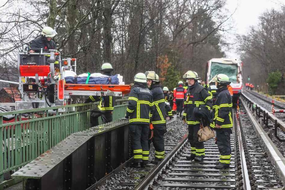 Feuerwehrleute transportieren eine Trage mit einem Verletzten ab.