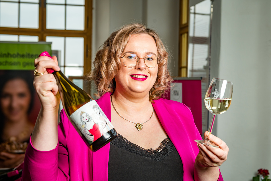 Winzerin Maria Lehmann (33) zeigt stolz den neuen "Hoheiten-Wein". Weinkönigin und Prinzessinnen zieren das Etikett.