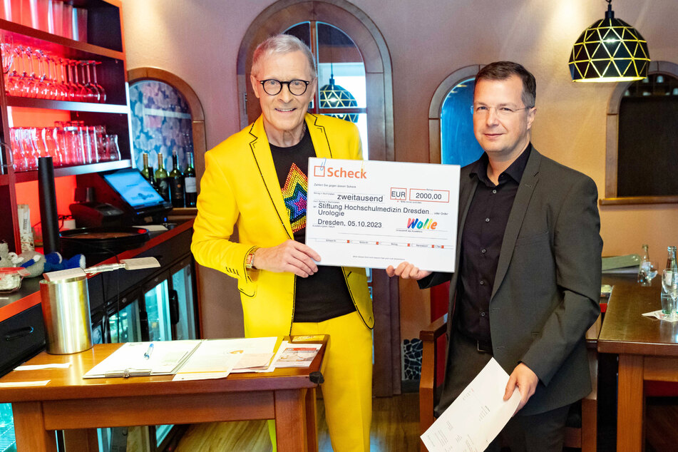 Wolle Förster (68, l.) übergibt an Prof. Christian Thomas (46) eine 2000-Euro-Spende für die Stiftung Hochschulmedizin Dresden.
