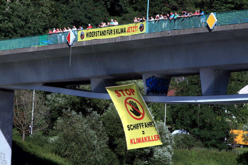 Alles nur fürs TV: An der Brücke haben Klimaaktivisten ein großes Protestbanner entrollt.