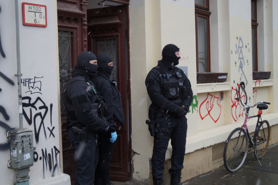Vermummte Polizisten vor einer Haustür im Stadtteil Connewitz.
