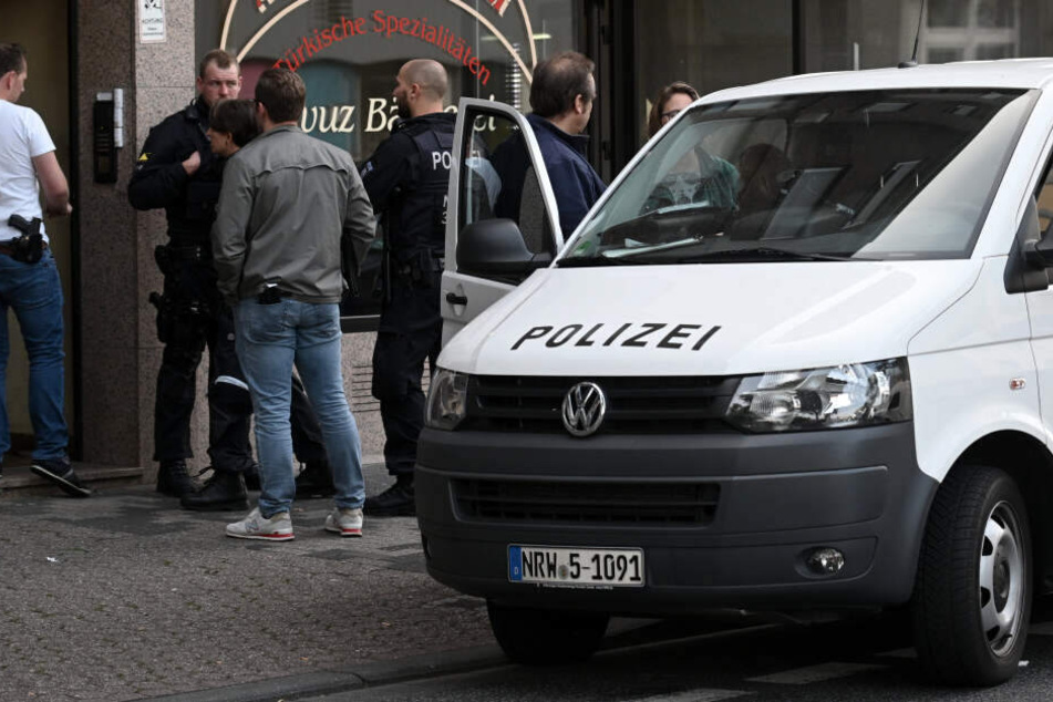 Polizeibeamte stehen vor einem Haus in der Josef-Schregel-Straße, das wegen Terrorverdachts durchsucht wird.