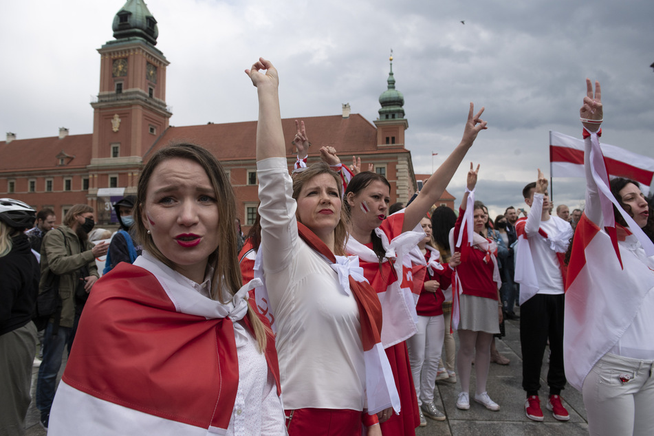 In historische belarussische Nationalfahnen gehüllte Frauen nehmen an einer Demonstration zur Unterstützung der regierungskritischen Proteste in Belarus teil. Die Gewinnerinnen des Preises, die darüber berichtet hatten, sitzen im Knast.