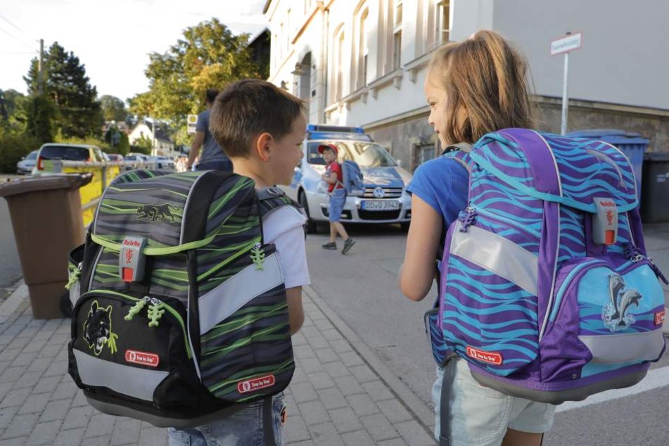Anton und Paulina Brückom (beide 6) liefen am Montag das erste Mal zur Schule - im Hintergrund passte die Polizei auf.