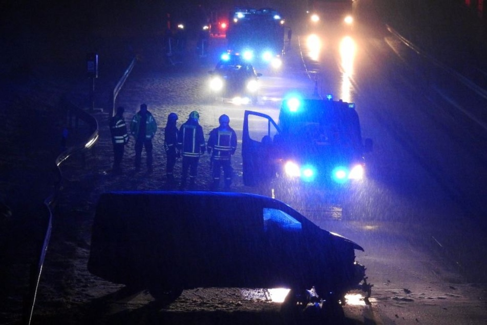 Einsatzkräfte stehen an der Unfallstelle zwischen Mutzschen und Grimma. Kurz zuvor ist hier der Transporter (unten) in die Leitplanke gekracht.