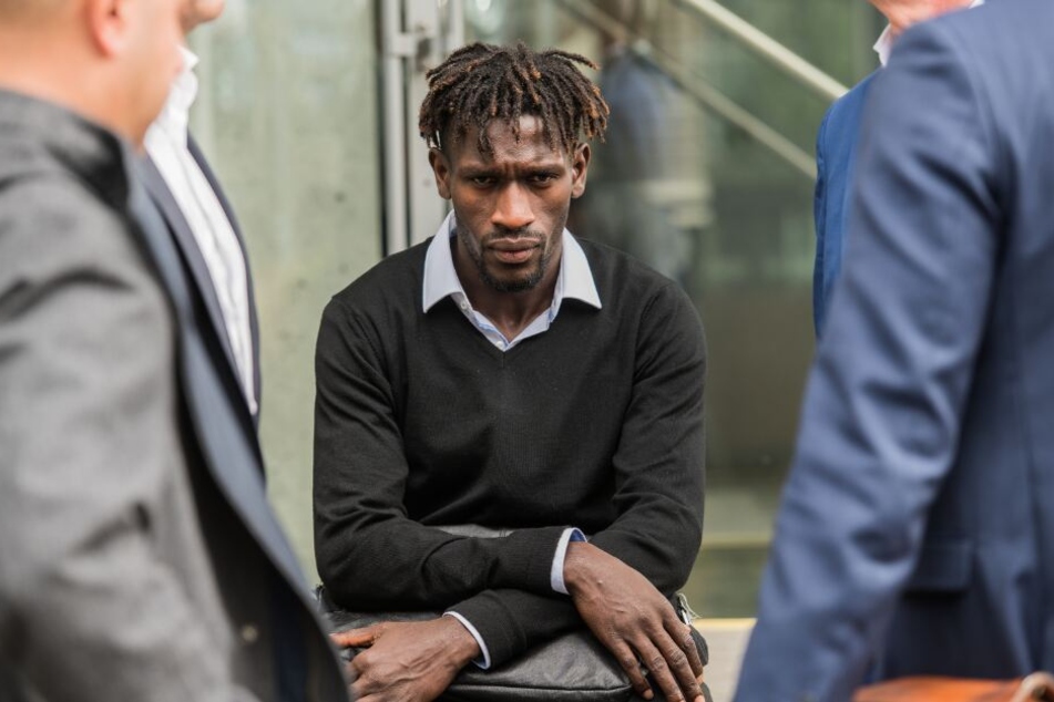 Bakery Jatta sitzt auf dem DFB-Gelände zwischen HSV-Vertretern.