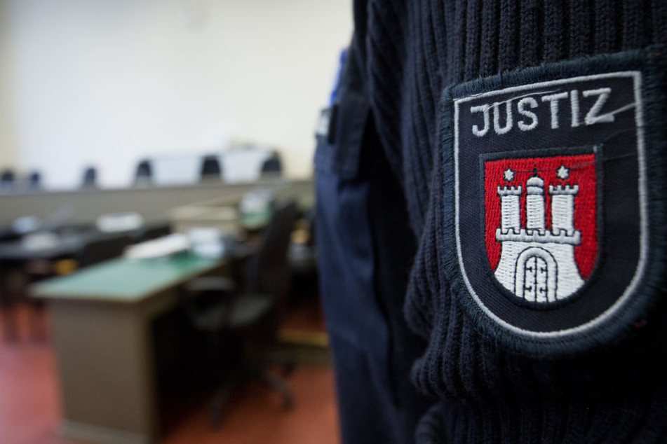 Ein Justizbeamter steht in einem Gerichtssaal des Strafjustizgebäudes.