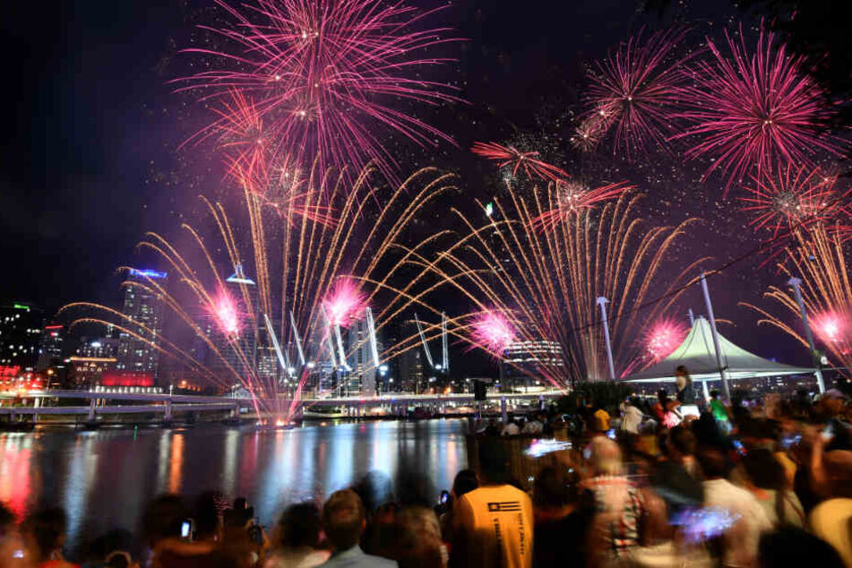 Menschen beobachten ein Feuerwerk in Brisbane.