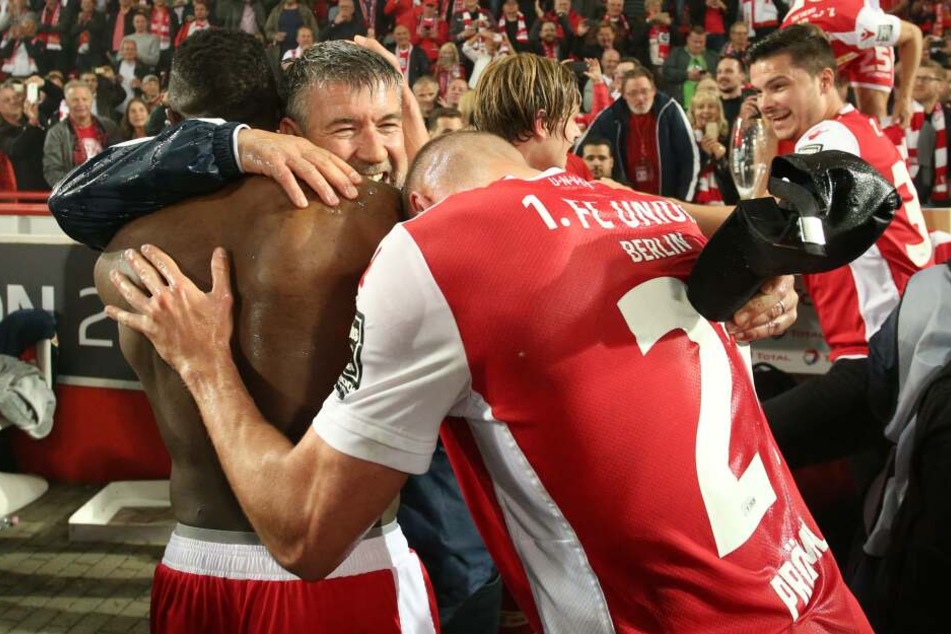 Suleiman Abdullahi, Trainer Urs Fischer und Grischa Prömel liegen sich beim Aufstiegsjubel in den Armen.