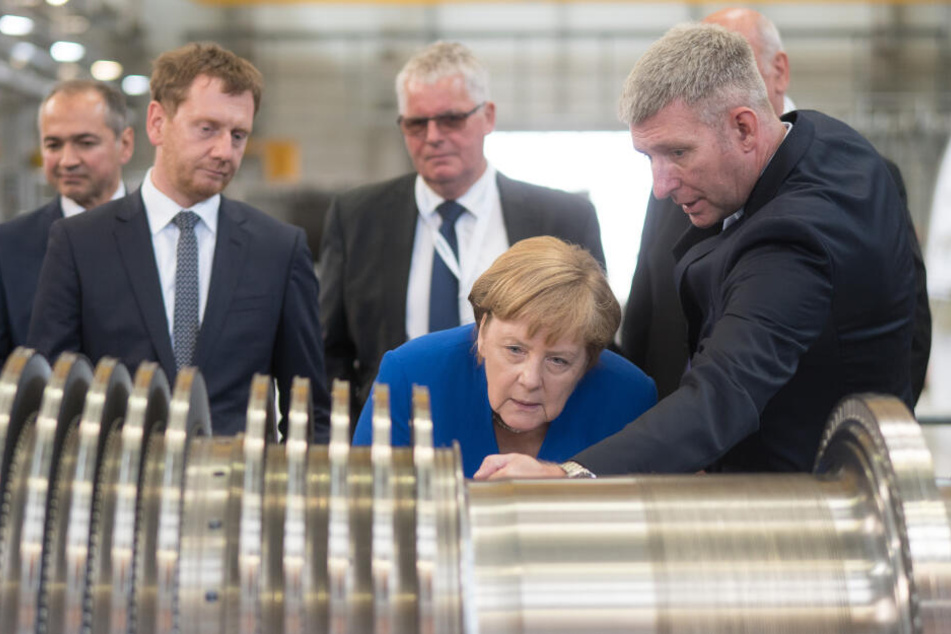 Der Leiter des Siemens-Werks Görlitz zeigt Bundeskanzlerin Angela Merkel die Details einer Turbine.