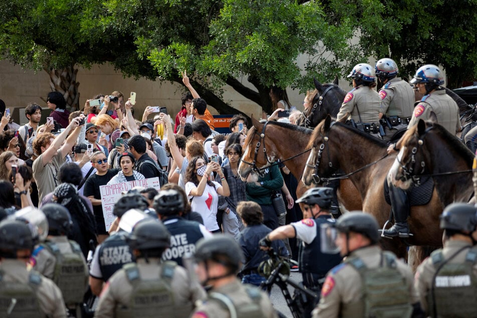 Law enforcement officers, some on horseback, face off against pro-Palestinian protesters at the University of Texas at Austin.
