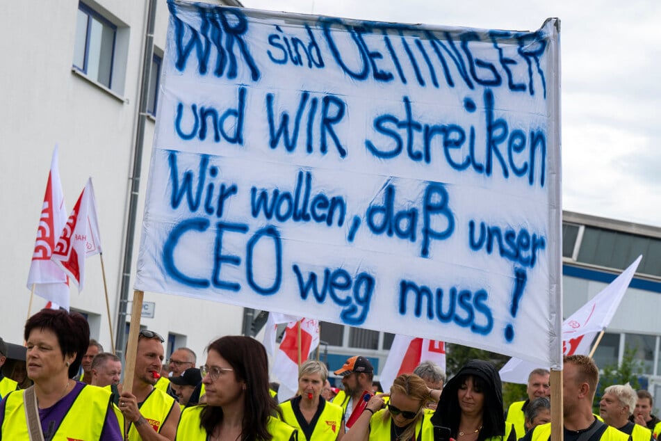 Mitarbeiter der Oettinger-Brauerei demonstrieren im Zufahrtsbereich der Brauerei. Am Montag wollen sie vorerst wieder die Arbeit aufnehmen.