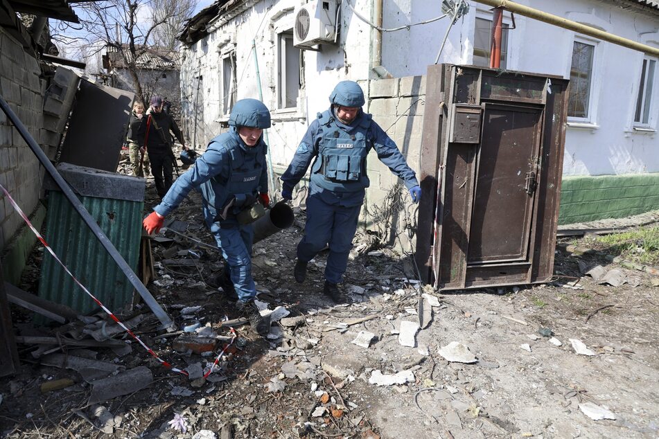 Rettungskräfte ziehen die Reste einer Rakete aus den Trümmern eines zerstörten Hauses in den kontrollierten Gebieten der "Volksrepublik" Donezk im Osten der Ukraine.