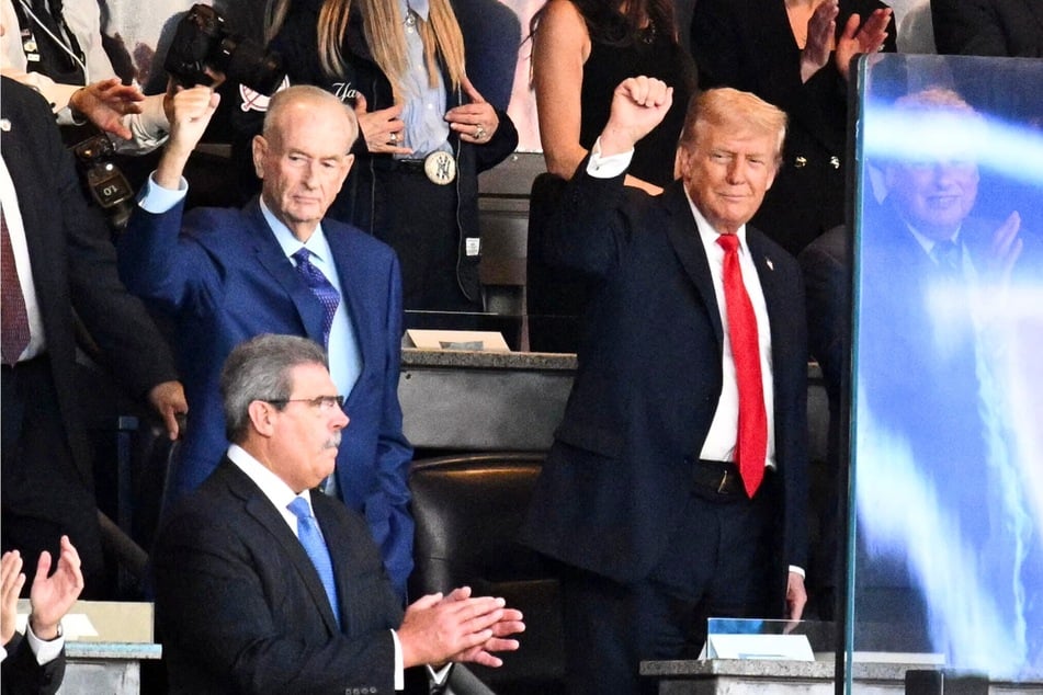On Thursday, President Donald Trump (r.) attended a New York Yankees baseball game, where he was met with a mix reaction of cheers and boos.
