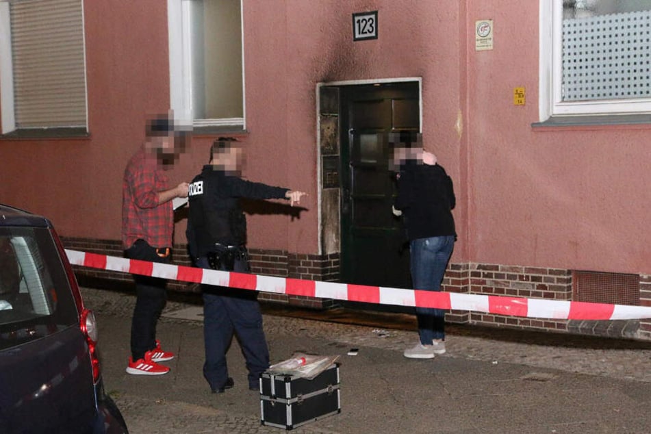 Kriminalpolizisten stehen vor dem Haus.