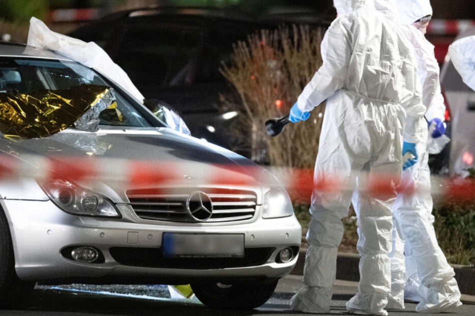 Forensiker arbeiten am Tatort in Hanau-Kesselstadt an einem Mercedes.