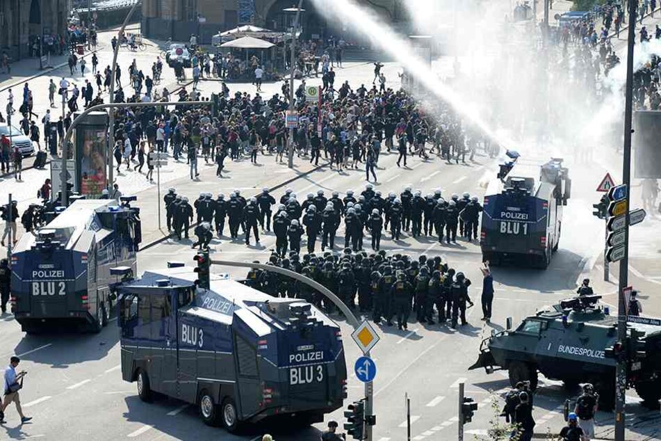 Nahe den Landungsbrücken setzen die Polizisten Wasserwerfer gegen Demonstranten ein.