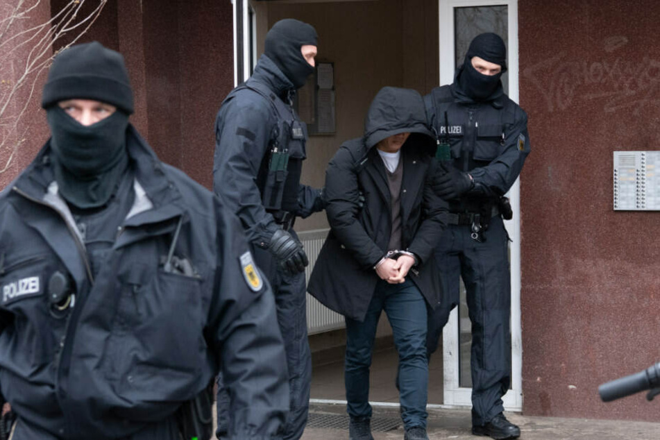 Zwei Polizisten führen in Berlin-Mitte eine tatverdächtige Person ab.