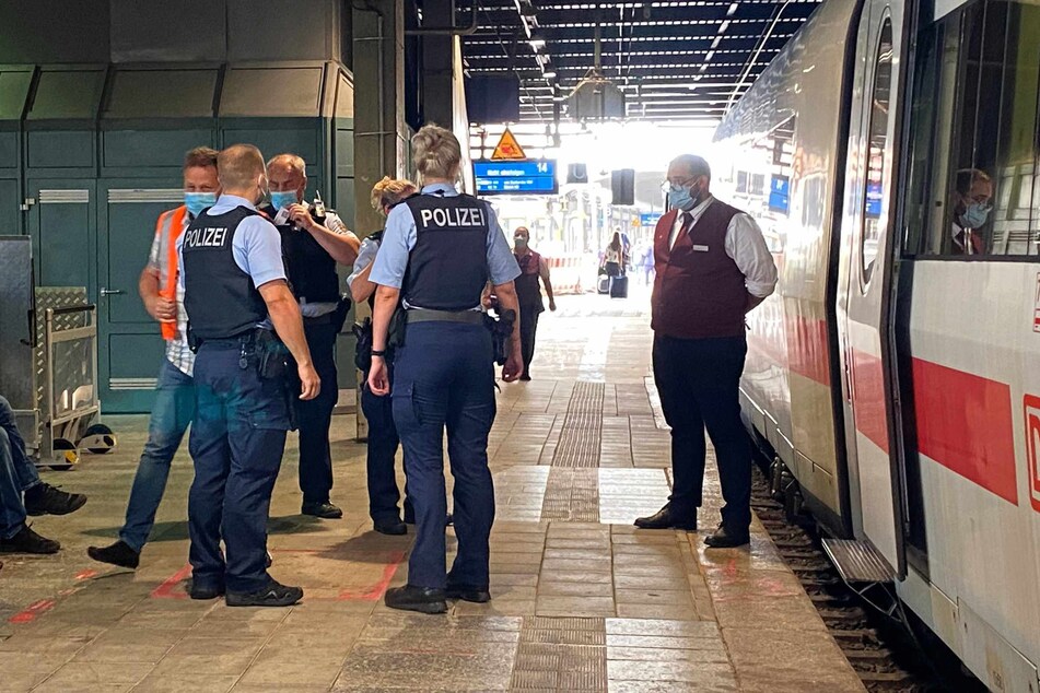Die Bundespolizei steht mit einem Bahn-Mitarbeiter vor dem ICE.