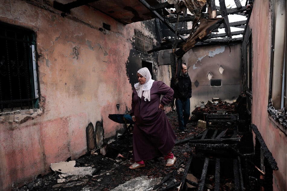 Palestinians inspect a damaged house burned by Israeli settlers the night before in Al-Fandaqumiya, near Jenin, in the Israeli-occupied West Bank, on March 22, 2026.