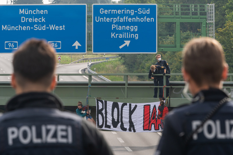 Aktivisten haben sich am Eröffnungstag der IAA Mobility von Autobahnbrücken rund um München abgeseilt und Banner entrollt.