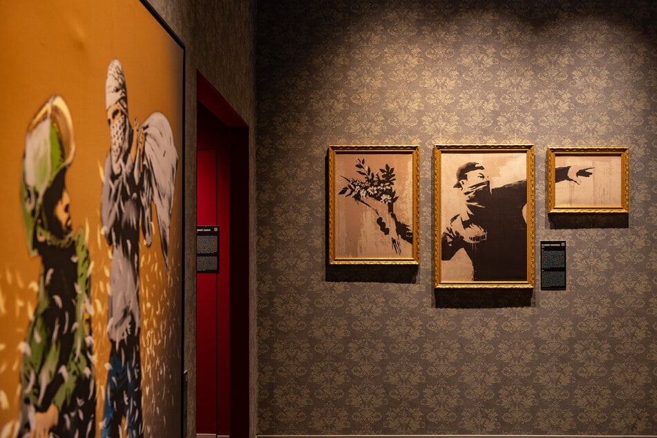 Müsste in der Hand des Mannes nicht eigentlich etwas Gewaltvolles sein? - Banksy überzeugt mit seinen starken Kontrasten.