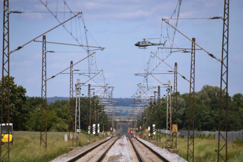 Ein Hubschrauber transportiert über der am Pfingstwochenende 2019 gesperrten Bahnstrecke Augsburg-Donauwörth einen Signalmasten der Bahn.