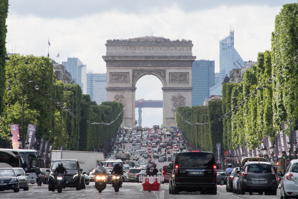 Autos fahren über die Champs-Elysees unweit des Arc de Triomphe. Mit Ausnahme der großen Verkehrsachsen und des Stadtrings Périphérique sollen Autos in Frankreichs Hauptstadt nur noch maximal 30 Stundenkilometer schnell fahren dürfen.