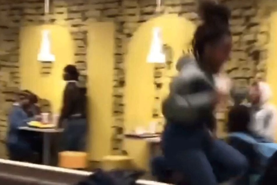 Eine Frau läuft in Panik über die Bänke.