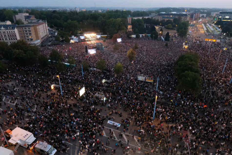 Zuschauer stehen während des Konzerts unter dem Motto «#wirsindmehr» auf dem Parkplatz vor der Johanniskirche.
