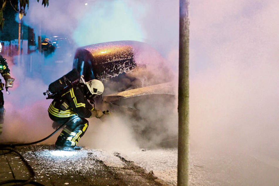 Feuerwehrleute löschen in Leipzig-Leutzsch einen brennenden Dienstwagen der Deutschen Bahn.