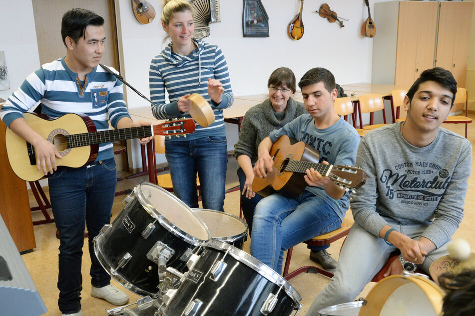 Afghane Khaled (15, l.), Lehrerin Lisa Berger, Schulleiterin Elke Fischer, Syrer Mohamad (18) und Serbe Stefan (15) bei einem Musikprojekt in der Oberschule Paunsdorf in Leipzig.