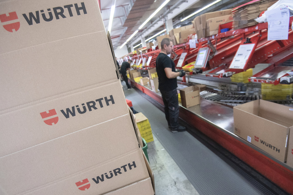 Ein Mitarbeiter des Großhändlers für Befestigungs- und Montagetechnik Würth steht an einer Kommissionierungsstraße.