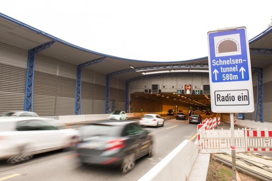 Autos fahren auf der Autobahn 7 bei Schnelsen in den Schnelsen-Tunnel mit dem Lärmschutzdeckel.