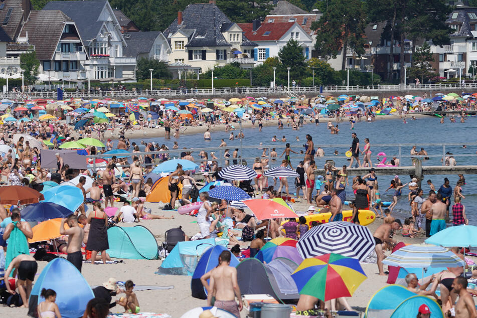 Urlauber und Tagestouristen genießen das Sommerwetter am Ostseestrand in Travemünde.