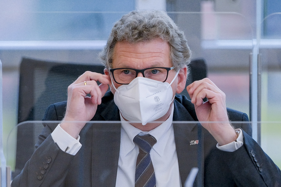 Bernd Buchholz (FDP), Minister des Landes Schleswig-Holstein, setzt sich im Plenarsaal des Landtags eine FFP2-Maske auf.