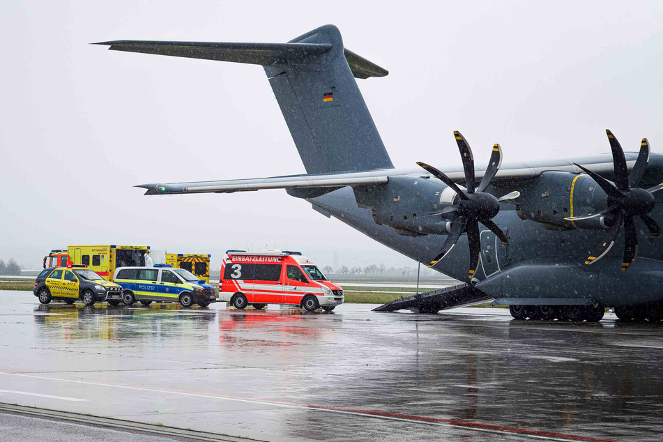 Rettungsfahrzeuge der Bundeswehr stehen hinter einem Transportflugzeug der Luftwaffe in Stuttgart am Sonntag.