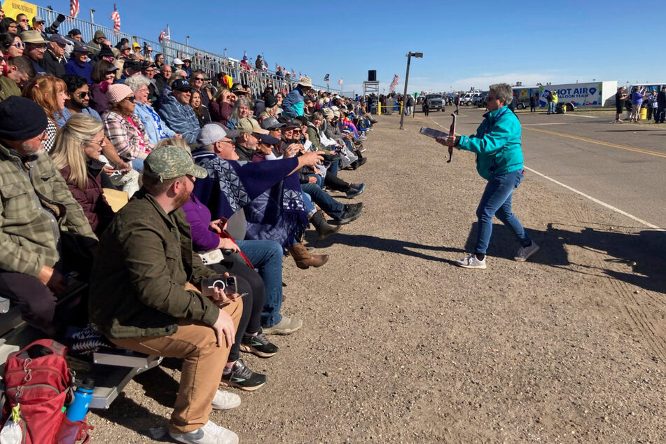 Ein Freiwilliger verteilt Brillen an Zuschauer für die Beobachtung der Sonnenfinsternis auf der Albuquerque International Balloon Fiesta in New Mexico.