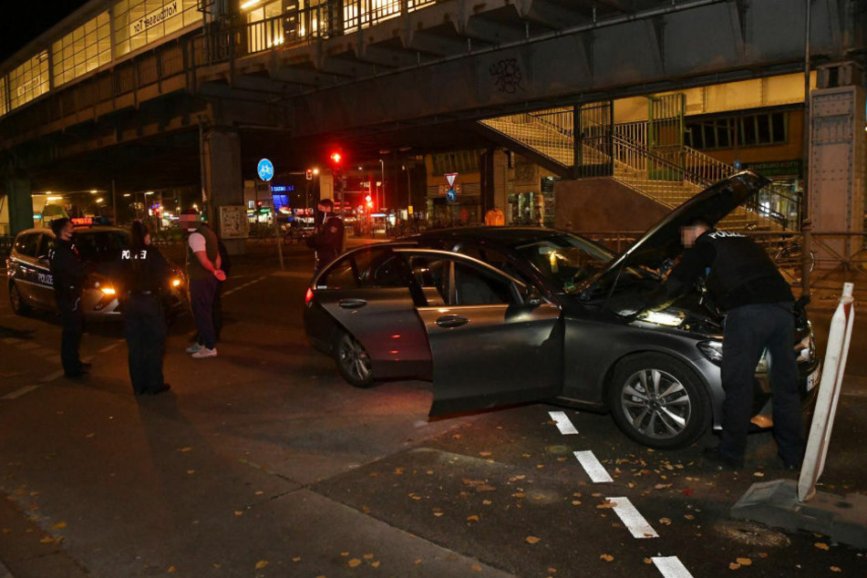 Ein Polizist durchsucht den Motorraum des Mercedes nach verdächtigen Gegenständen.
