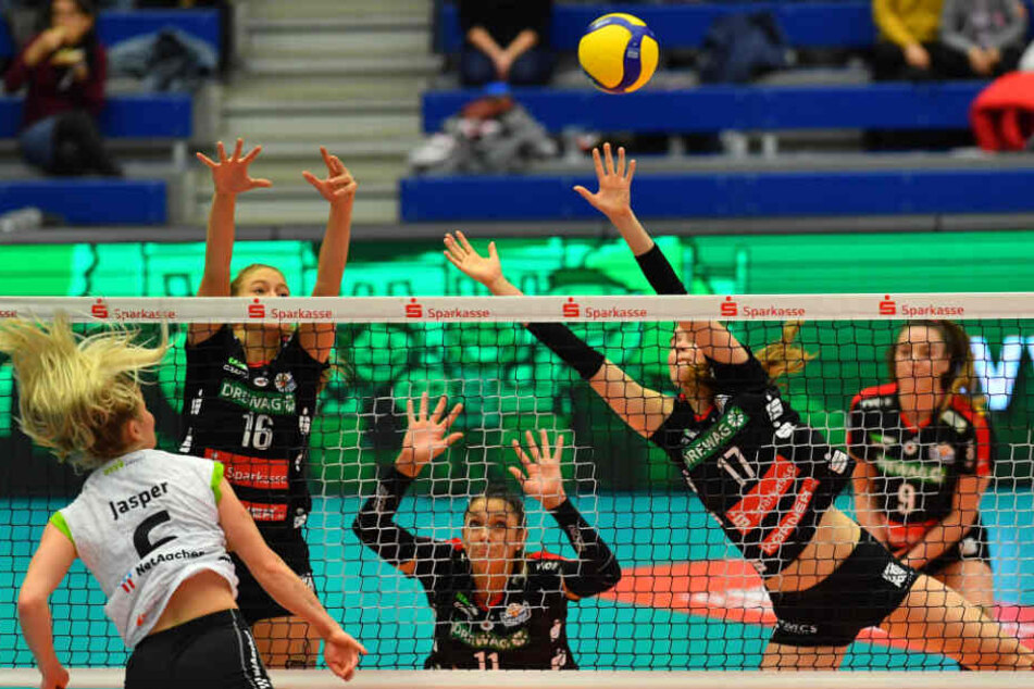 Die DSV-Volleyballerinnen Brie King (v.l.n.r.), Milica Kubura und Camilla Weitzel blocken den Ball von Aachens Marrit Jasper am Netz.
