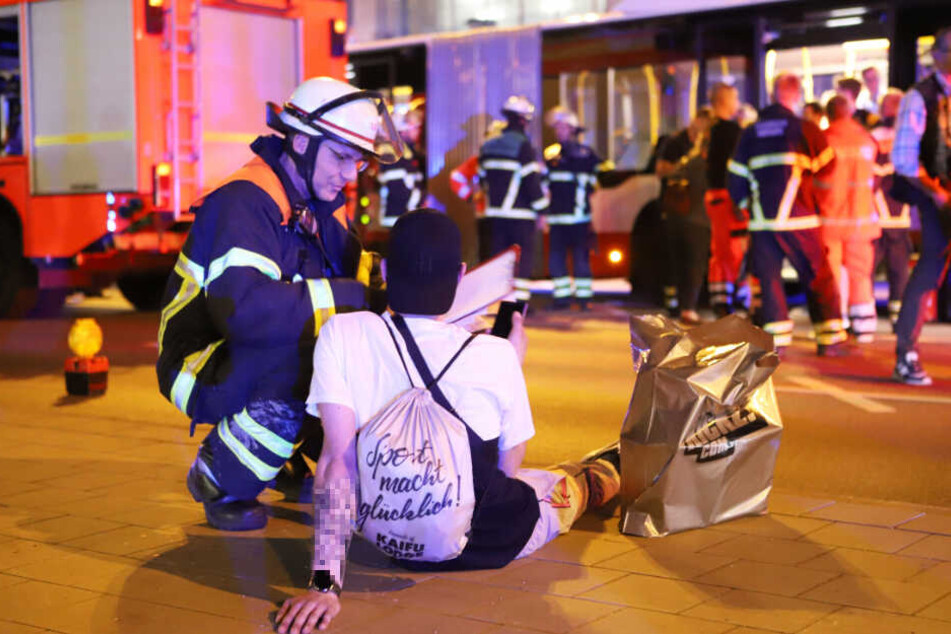 Ein Feuerwehrmann betreut einen Bus-Insassen nach dem Unfall.