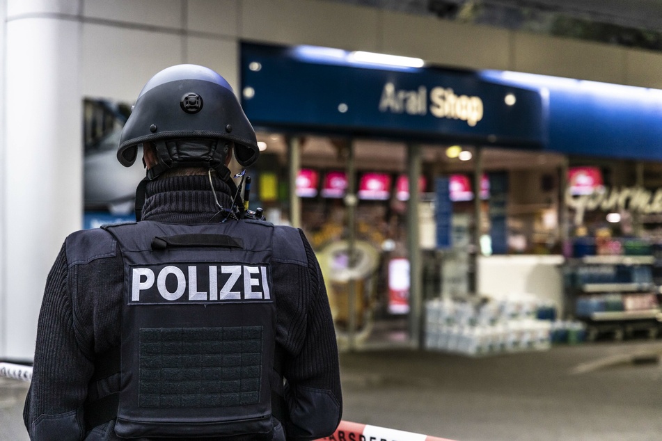 Ein Polizist sichert am frühen Morgen eine Tankstelle. Ein Angestellter der Tankstelle war in Idar-Oberstein in Rheinland-Pfalz von einem mit einer Pistole bewaffneten Mann erschossen worden.