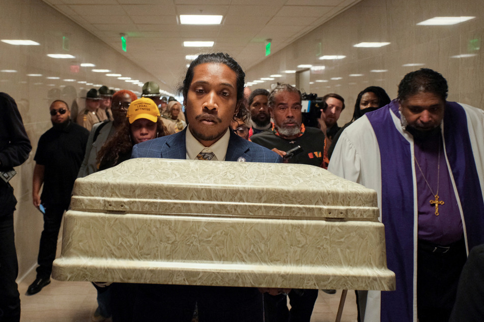 State Rep. Justin Jones carries a coffin representing one of the victims of the Covenant School shooting into the state Capitol in Nashville, Tennessee.