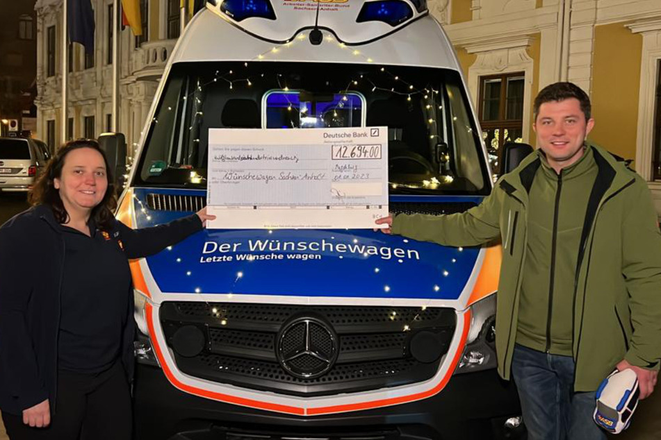 Lichterfahrt-Organisator Martin Dippe (rechts) überreicht Louisa Garthof vom ASB-Wünschewagen die Spendensumme von fast 12.700 Euro.